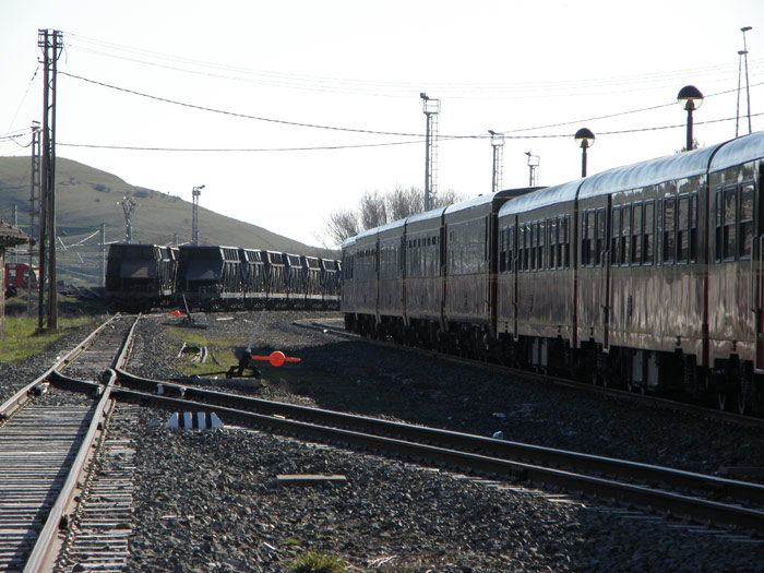 Los coches del Expreso de La Robla a pocos metros de tolvas cementeras de Renfe