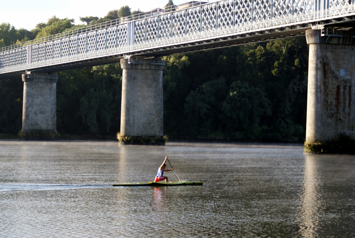 Un pirag�ista surca el tranquilo cauce del Mi�o bajo el puente del ferrocarril. Foto Pablo M�n�ndez